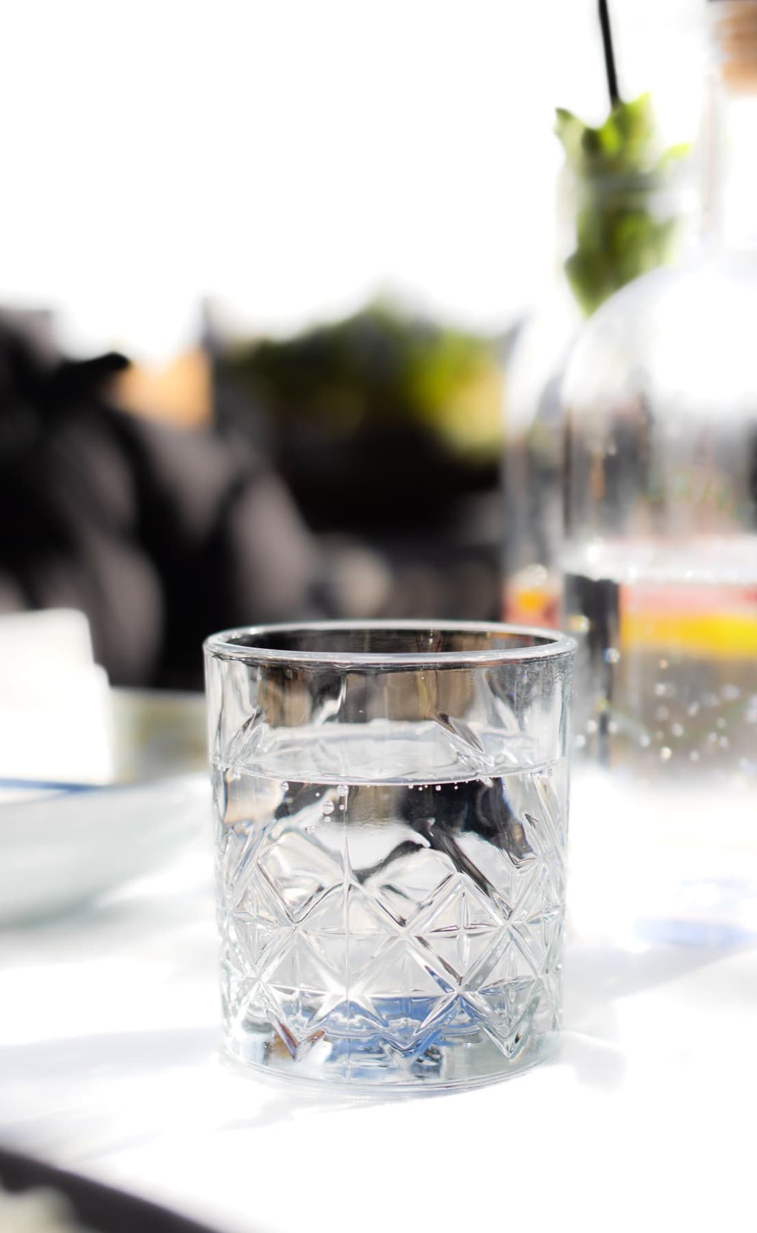 A glass of water on a bright table.
